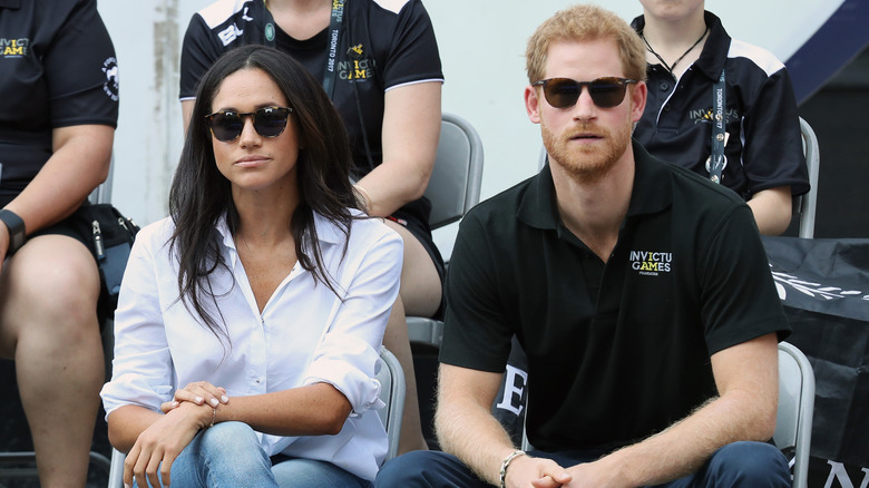 Prince Harry and Meghan Markle looking sullen