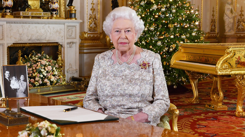 Queen Elizabeth II sitting at a desk