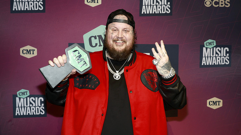 Jelly Roll smiling and holding CMT award