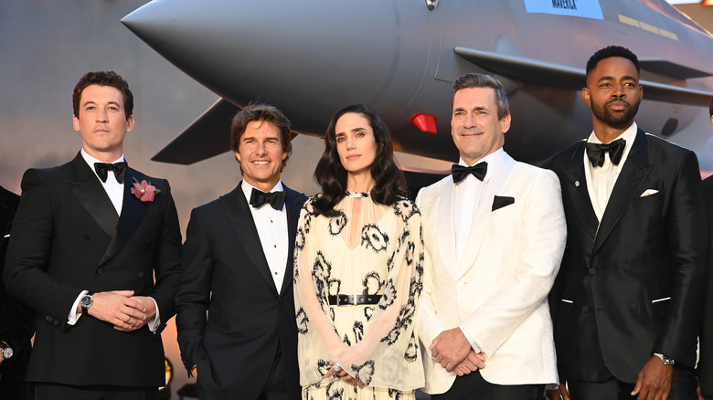 Top Gun: Maverick cast including Tom Cruise and Jennifer Connelly standing by a plane