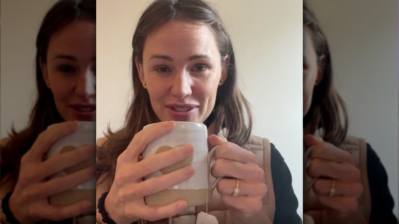 Jennifer Garner holding mug with diamond ring on