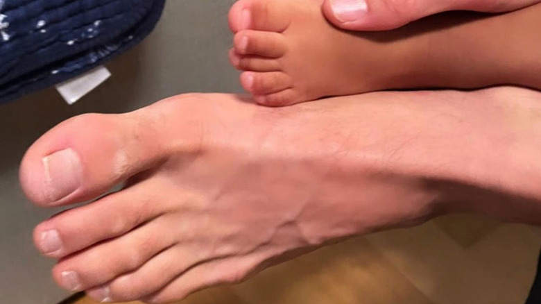 Joshua Jackson and Jodie Turner-Smith's daughter's foot is shown next to Joshua's foot