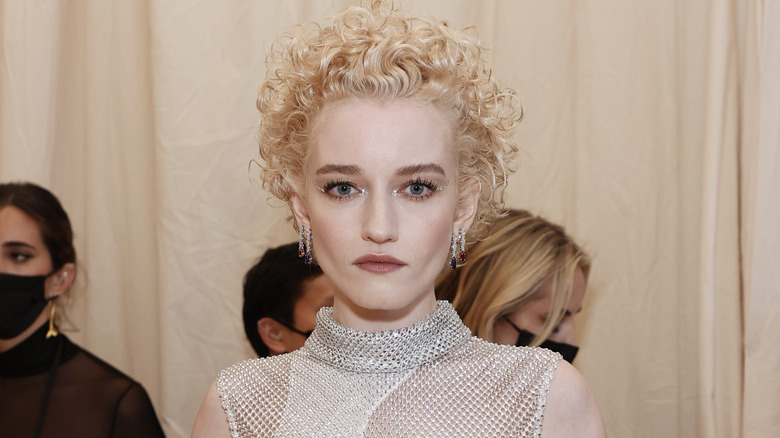 Julia Garner poses in a silver dress