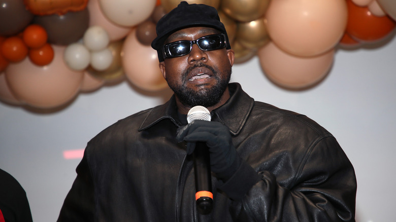 Kanye West, holding microphone