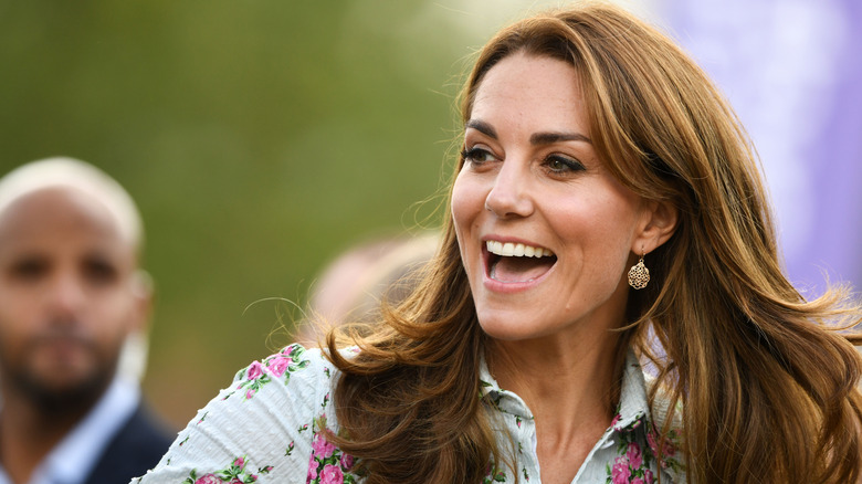 Kate Middleton smiling with hair blowing in wind