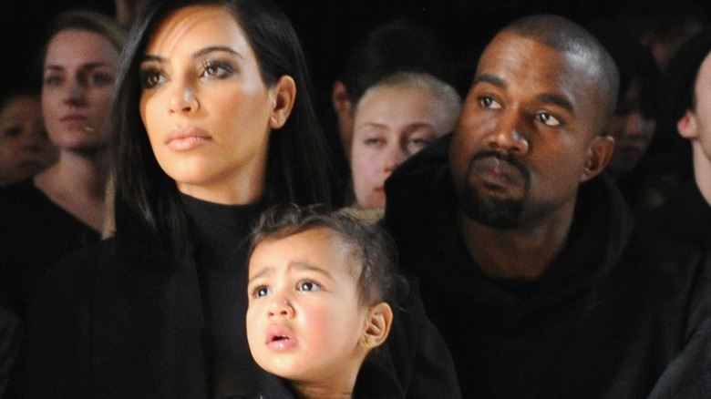 Kim Kardashian, Kanye, and North West, all looking away