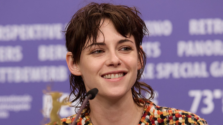Kristen Stewart smiling in front of a microphone