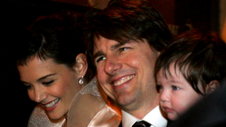 Katie Holmes and Tom Cruise smiling with Suri Cruise