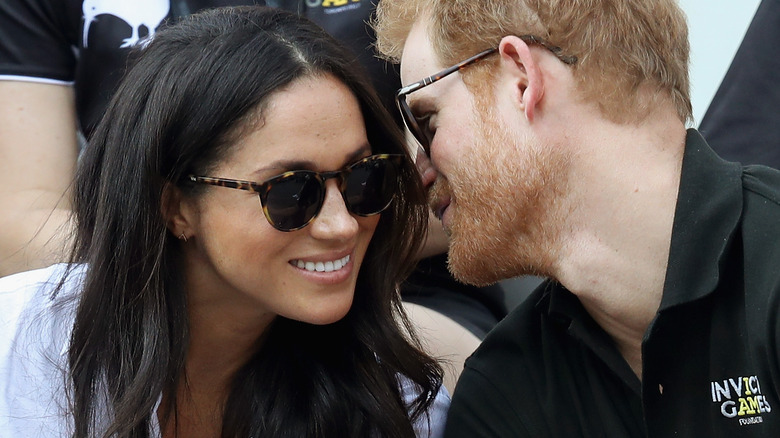 Harry and Meghan whisper and smile to each other in Toronto