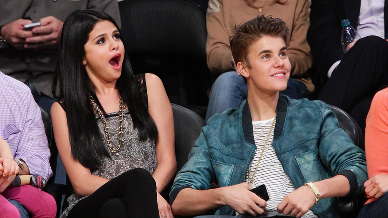 Justin Bieber and Selena Gomez watching a basketball game