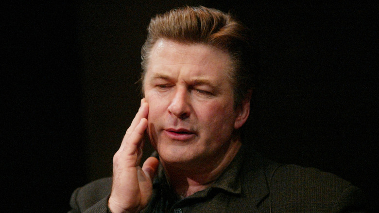 Alec Baldwin touching face