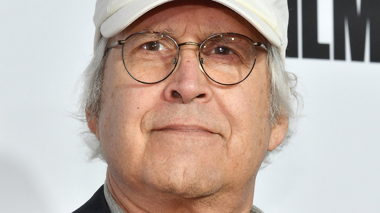 Chevy Chase wearing cap, glasses