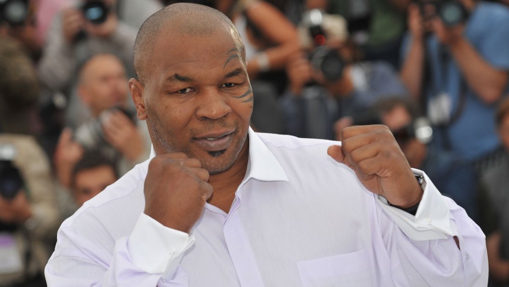 Mike Tyson with fists up, posing in white shirt