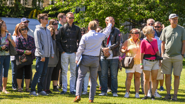 A Buckingham Palace tour guide with a group of tourists