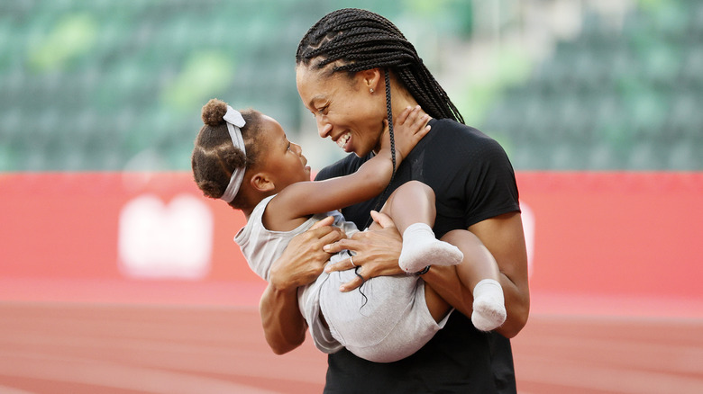 Allyson Felix, holding her daughter Camryn on the track field