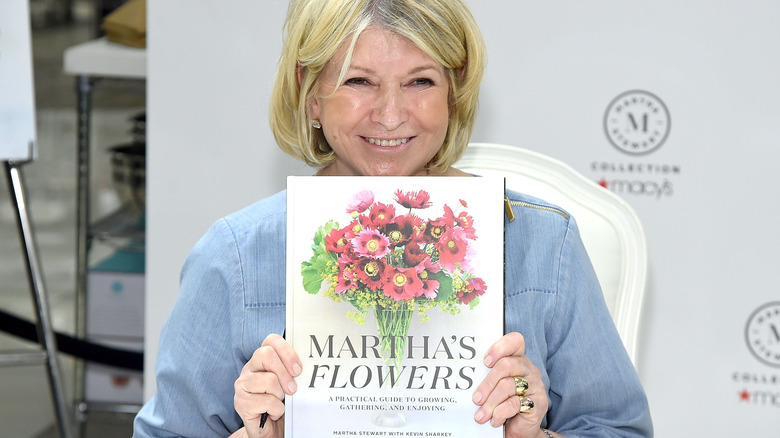 Martha Stewart holding her book