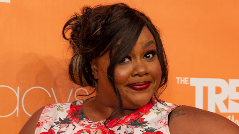 Nicole Byer posing at a red carpet event