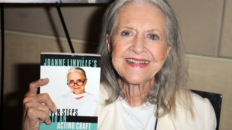 Joanne Linville, holding her book