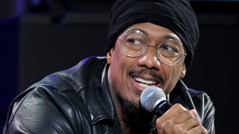 Nick Cannon wears glasses and a leather jacket