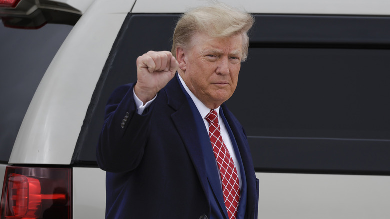 Donald J. Trump disembarking from his plane while raising his fist in the air