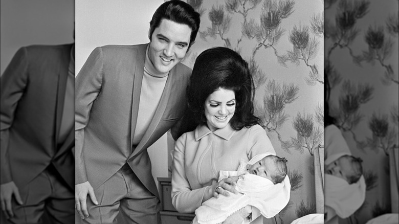 Elvis Presley and Priscilla Presley smiling with baby