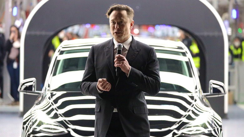 Elon Musk in front of a Tesla