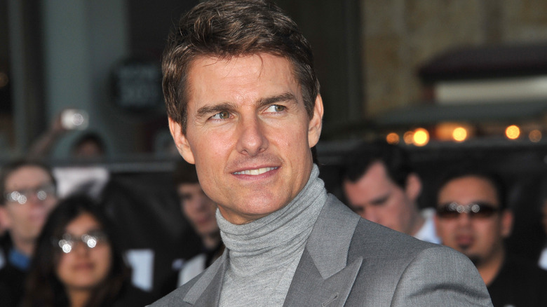 Tom Cruise smiling in grey suit and turtleneck