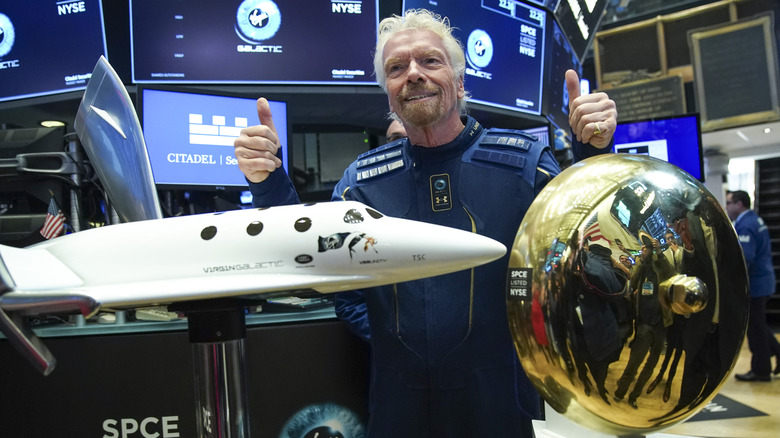 Richard Branson giving thumbs up in front of plane model