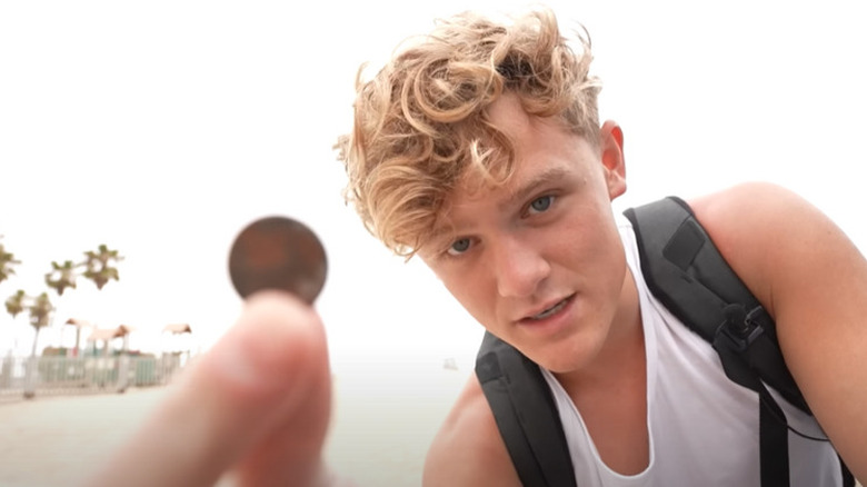 Ryan Trahan holding a penny