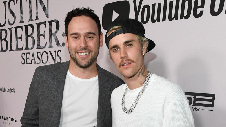 Scooter Braun and Justin Bieber smiling on the red carpet 