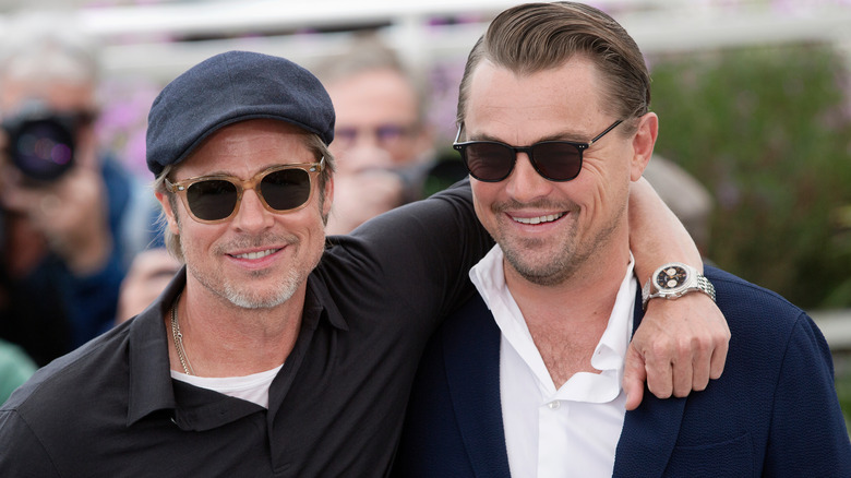 Brad Pitt smiling with arm around Leonardo DiCaprio