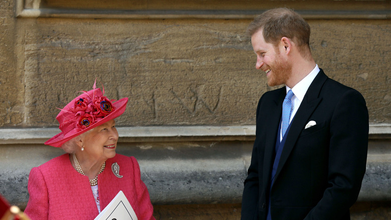 Queen Elizabeth and Prince Harry smiling at each other