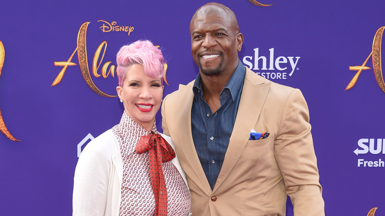 Rebecca and Terry Crews smiling on red carpet