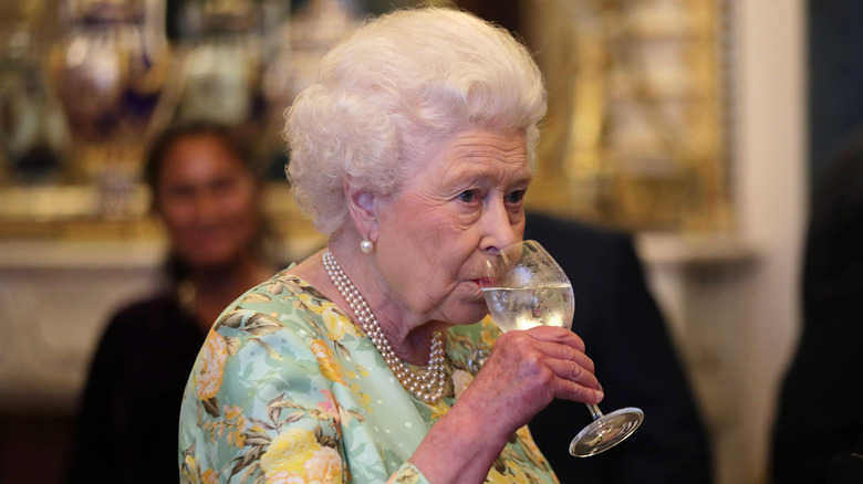 Queen Elizabeth II drinking from a glass