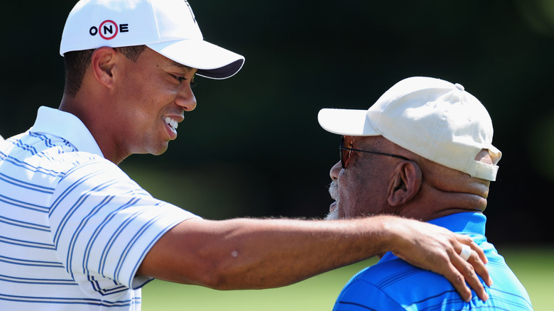 Tiger Woods puts his arm on Charlie Sifford's shoulder