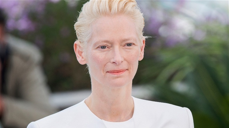 Tilda Swinton standing in front of palms