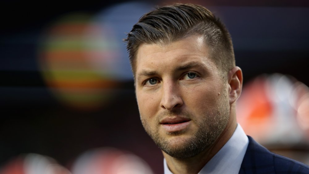 Tim Tebow in a suit, with a serious expression