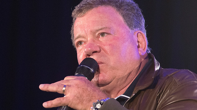 William Shatner holding a microphone