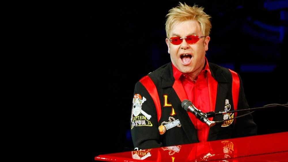 Elton John singing and playing piano