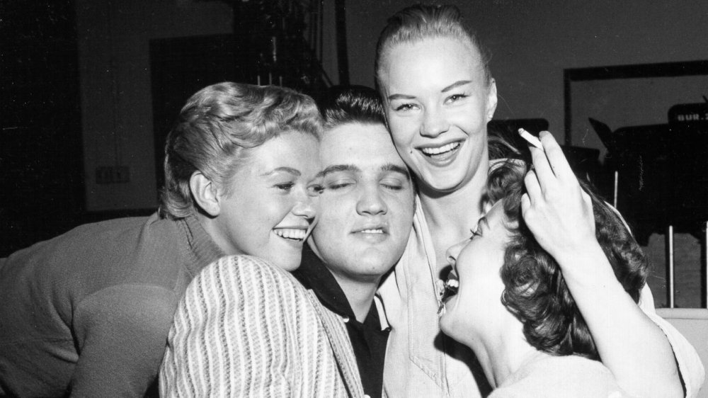 Elvis Presley is mobbed by girls on the set of the "Milton Berle Show" in 1956.