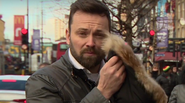 A BBC presenter holding up a fur coat