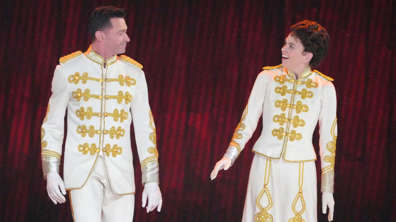 Hugh Jackman and Sutton Foster wearing white and gold band uniforms