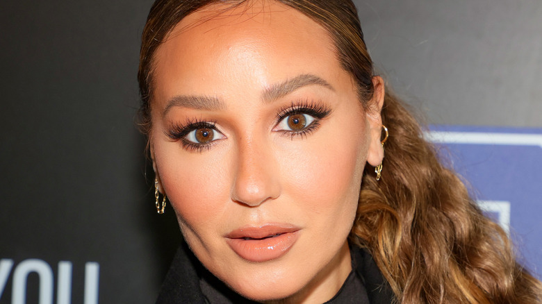 Adrienne Bailon Houghton with full makeup and surprised expression