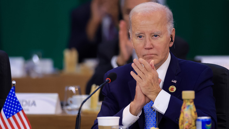 Joe Biden sitting at desk with his hands together