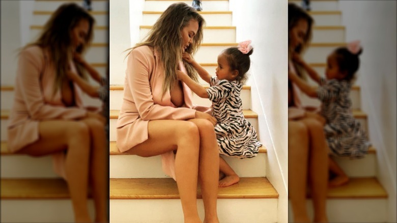 Chrissy Teigen taking a photo with her daughter, Luna