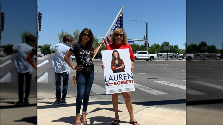 Lauren Boebert holding flag beside supporter