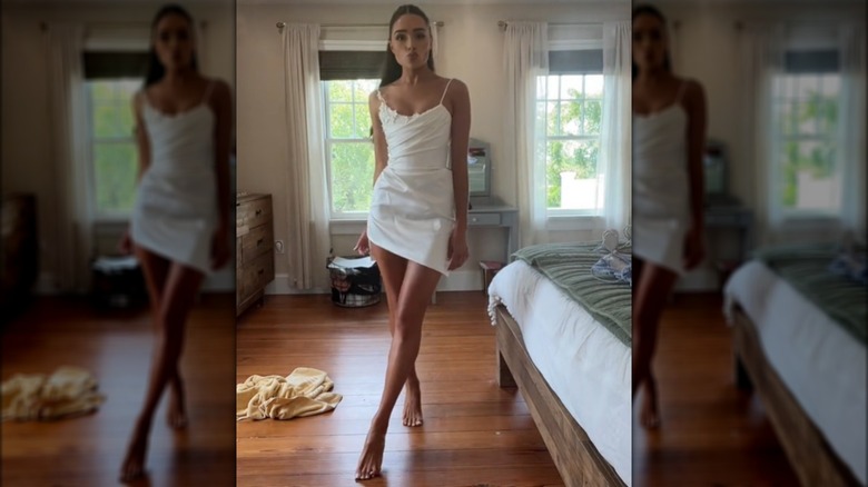 Olivia Culpo posing in white mini dress