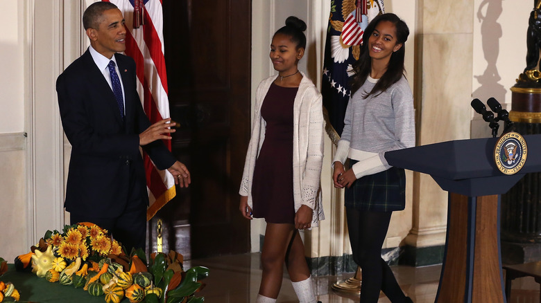 Malia (R) and Sasha Obama listen to their father U.S. President Barack Obama speak before pardoning "Cheese" and his alternate Mac both, 20-week old 48-pound during a ceremony at the White House