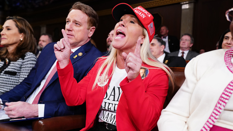 Marjorie Taylor Greene wearing red hat and blazer