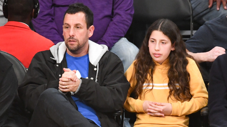 Adam Sandler and Sadie Sandler sitting at a game together